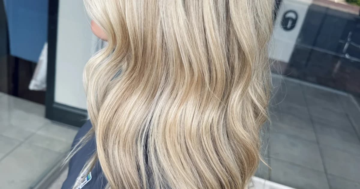 Platinum blonde dimensional balayage on long hair with beach waves by Brooke Holland